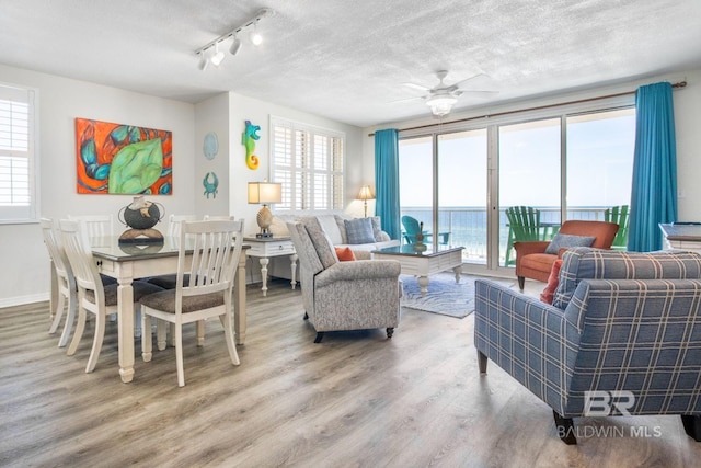 25360 Perdido Beach Blvd Unit 401, Orange Beach, AL 36561 - living area with wood finished floors, ceiling fan, a textured ceiling, and track lighting