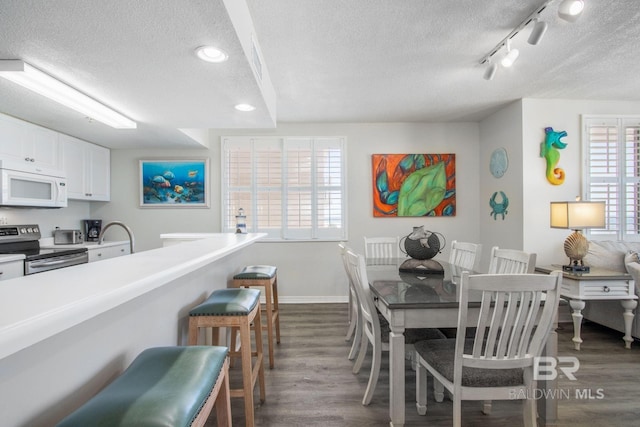 25360 Perdido Beach Blvd Unit 401, Orange Beach, AL 36561 - dining space featuring a textured ceiling, dark wood-style floors, track lighting, and recessed lighting