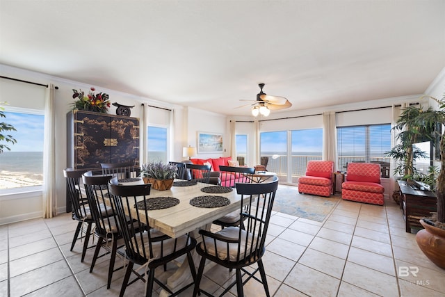 dining space featuring light tile patterned flooring, plenty of natural light, a ceiling fan, and ornamental molding