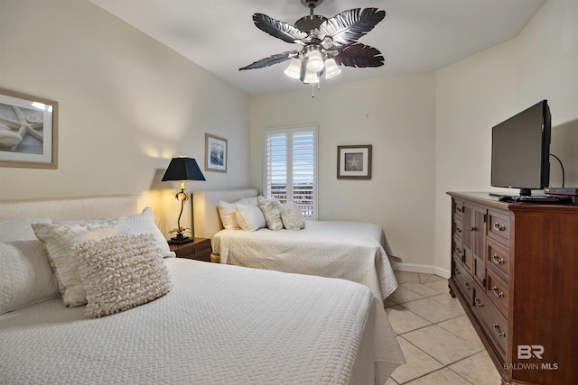 bedroom featuring light tile patterned floors, baseboards, and ceiling fan