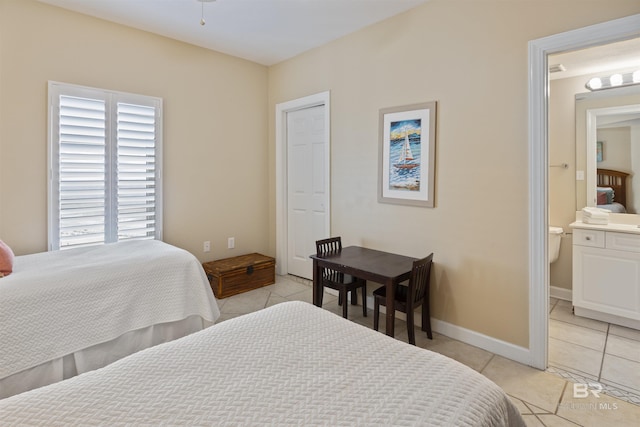 bedroom with light tile patterned flooring and connected bathroom