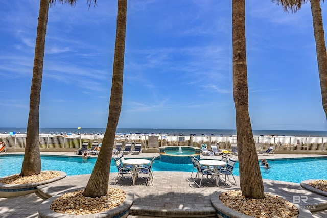 community pool with a patio and a water view