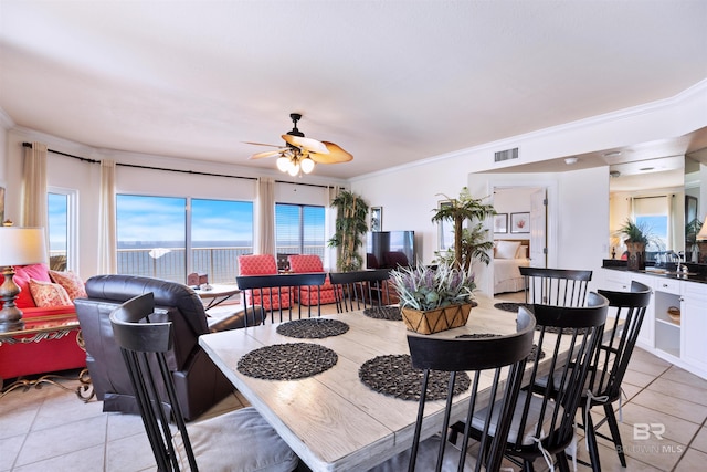 dining room with light tile patterned floors, a ceiling fan, and crown molding