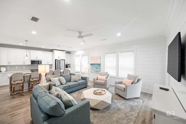 1476 Sandpiper Ln Unit B, Gulf Shores, AL 36542 - living room with light wood finished floors, ceiling fan, crown molding, and recessed lighting