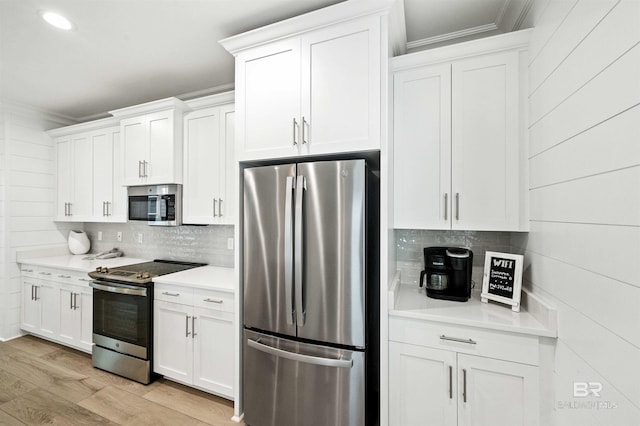 1476 Sandpiper Ln Unit B, Gulf Shores, AL 36542 - kitchen featuring appliances with stainless steel finishes, crown molding, light countertops, decorative backsplash, and light wood finished floors