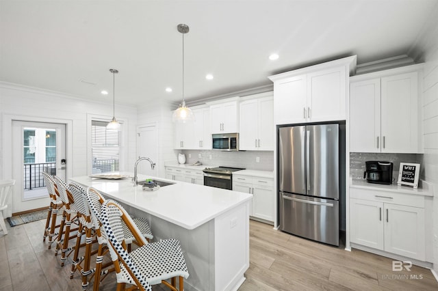 1476 Sandpiper Ln Unit B, Gulf Shores, AL 36542 - kitchen featuring appliances with stainless steel finishes, a sink, backsplash, light wood finished floors, and crown molding