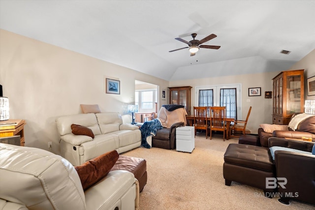 living room featuring vaulted ceiling, light colored carpet, and ceiling fan