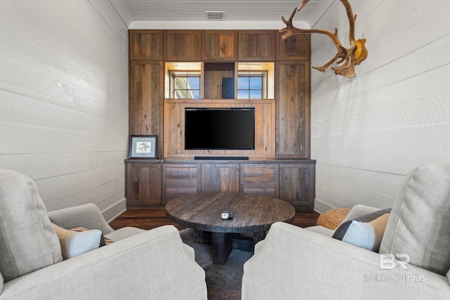 living room featuring wood-type flooring and wood walls