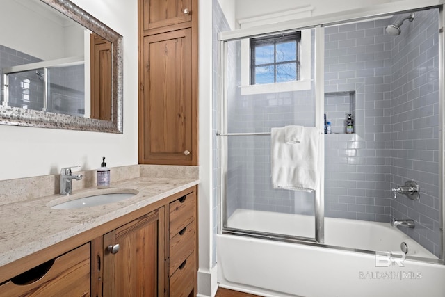 bathroom featuring combined bath / shower with glass door and vanity