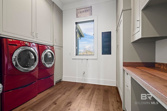 washroom featuring cabinets, independent washer and dryer, and light wood-type flooring