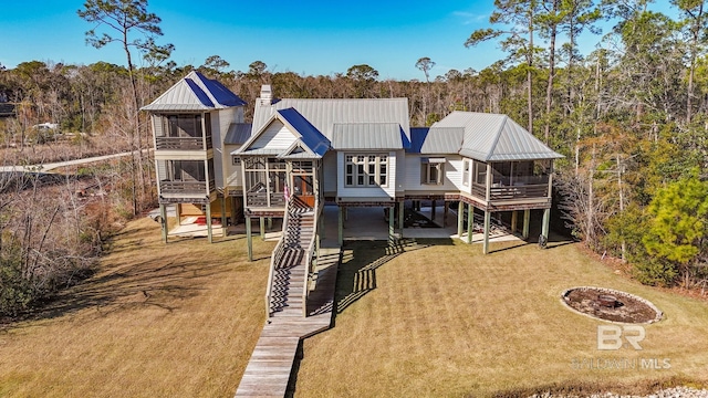 back of house with a sunroom and a lawn