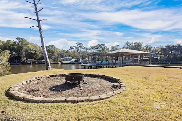 view of community with a gazebo, a lawn, a fire pit, and a water view