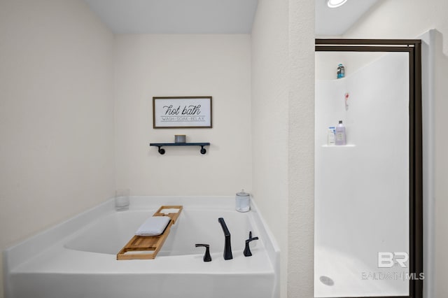 bathroom with a garden tub and a stall shower