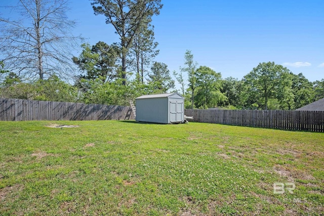 view of yard with a fenced backyard, an outbuilding, and a storage unit