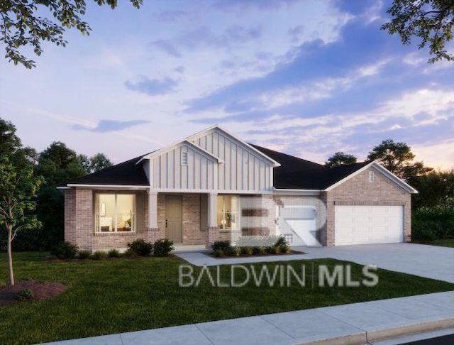 view of front of house featuring a garage, brick siding, a yard, driveway, and board and batten siding