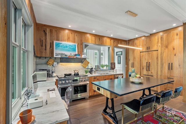 kitchen featuring appliances with stainless steel finishes, dark hardwood / wood-style flooring, beamed ceiling, sink, and pendant lighting