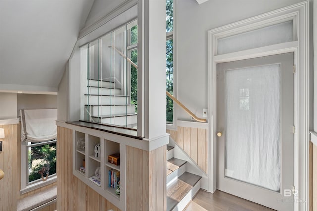 doorway to outside featuring vaulted ceiling, a healthy amount of sunlight, and light wood-type flooring