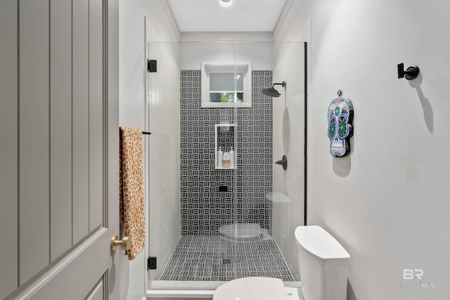 bathroom featuring toilet and a shower with door