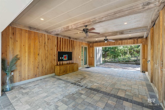 interior space featuring wood walls and ceiling fan