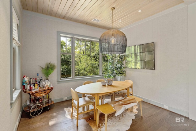 dining area with wood-type flooring, crown molding, and wood ceiling