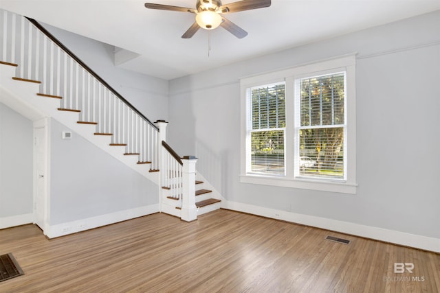 unfurnished living room with wood-type flooring and ceiling fan