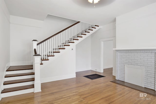 staircase featuring hardwood / wood-style flooring and ceiling fan