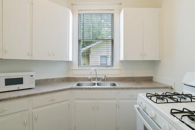 kitchen featuring white cabinetry, white appliances, and sink