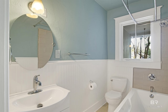 bathroom featuring vanity, toilet, and a washtub