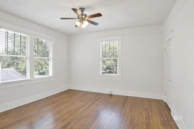 spare room with hardwood / wood-style flooring, a healthy amount of sunlight, and ceiling fan