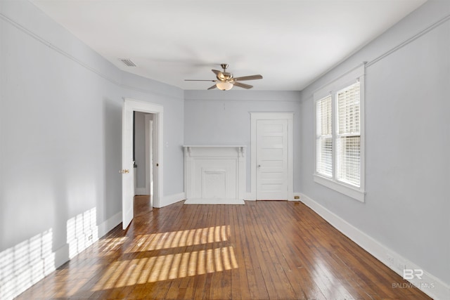 unfurnished living room featuring dark wood-type flooring and ceiling fan