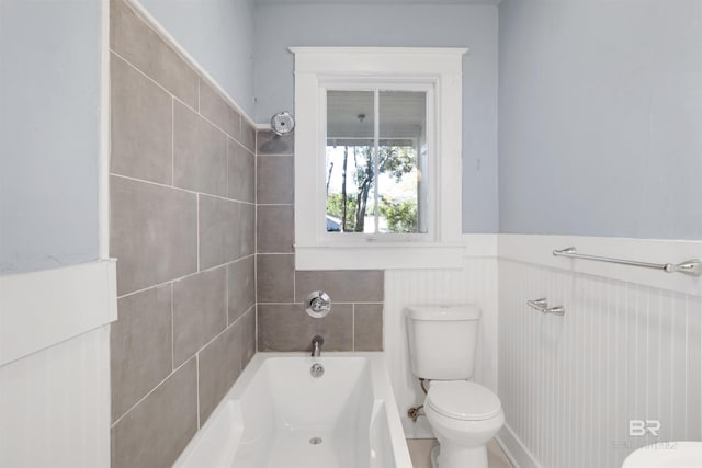 bathroom featuring tiled shower / bath and toilet