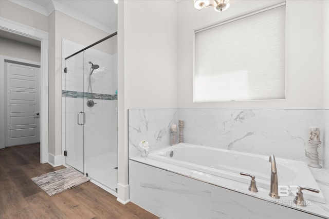 bathroom with ornamental molding, hardwood / wood-style flooring, and independent shower and bath