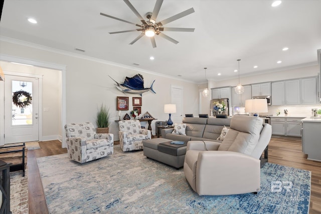 living room featuring ornamental molding, light hardwood / wood-style floors, and ceiling fan