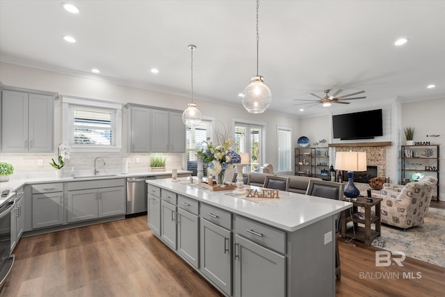 kitchen featuring ceiling fan, a kitchen island, dark hardwood / wood-style floors, gray cabinetry, and sink