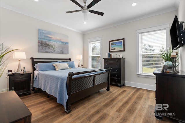 bedroom with crown molding, dark hardwood / wood-style floors, and ceiling fan