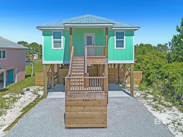 566 Boykin Ct N, Gulf Shores, AL 36542 - coastal home with board and batten siding, stairs, a porch, and a carport