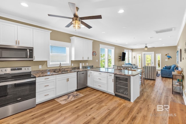 566 Boykin Ct N, Gulf Shores, AL 36542 - kitchen featuring appliances with stainless steel finishes, wine cooler, ceiling fan, a sink, and a peninsula