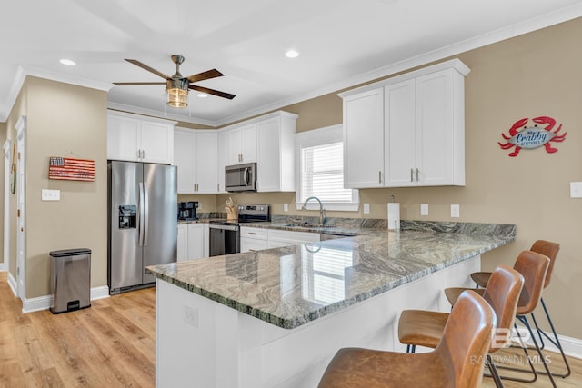 566 Boykin Ct N, Gulf Shores, AL 36542 - kitchen with stainless steel appliances, a sink, a peninsula, light stone countertops, and ornamental molding