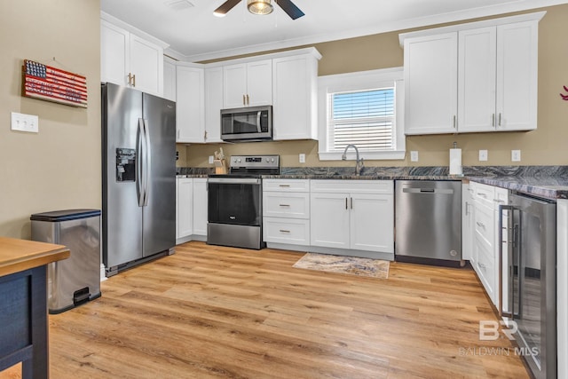 566 Boykin Ct N, Gulf Shores, AL 36542 - kitchen featuring appliances with stainless steel finishes, wine cooler, a sink, light wood-style floors, and a ceiling fan