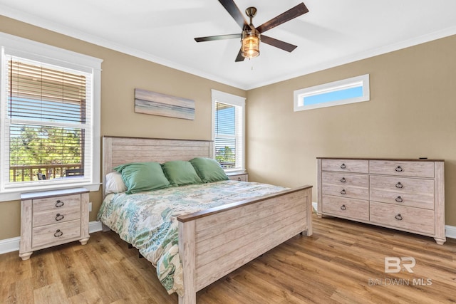 566 Boykin Ct N, Gulf Shores, AL 36542 - bedroom with wood finished floors, multiple windows, crown molding, and baseboards