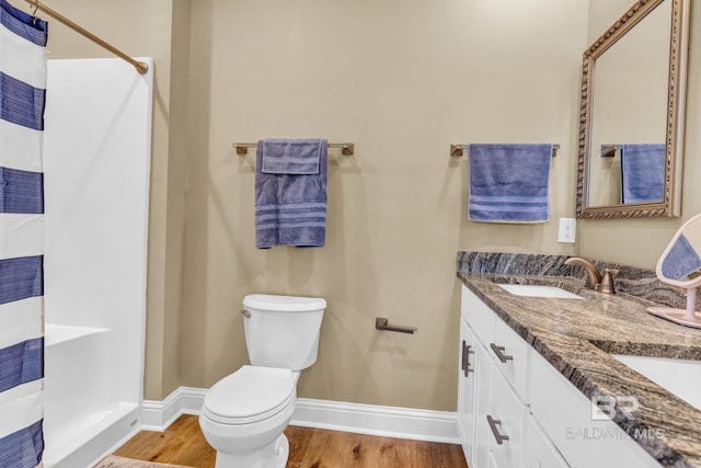 566 Boykin Ct N, Gulf Shores, AL 36542 - full bathroom featuring a shower with shower curtain, toilet, baseboards, wood finished floors, and double vanity