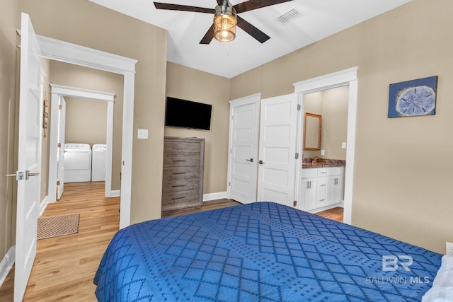 566 Boykin Ct N, Gulf Shores, AL 36542 - bedroom with washer and dryer, light wood-style floors, baseboards, and a sink