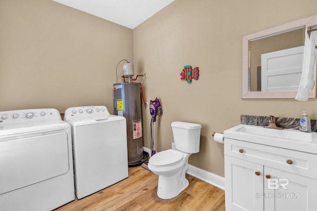 566 Boykin Ct N, Gulf Shores, AL 36542 - bathroom featuring washer and clothes dryer, electric water heater, wood finished floors, baseboards, and toilet