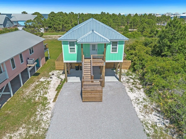 566 Boykin Ct N, Gulf Shores, AL 36542 - beach home with a carport, driveway, stairs, covered porch, and metal roof