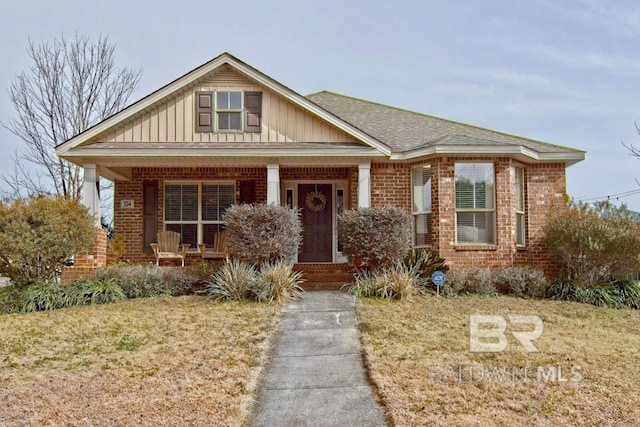 view of front of house featuring covered porch and a front lawn