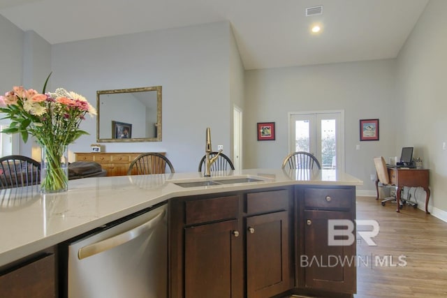 kitchen with sink, stainless steel dishwasher, dark brown cabinets, light wood-type flooring, and french doors