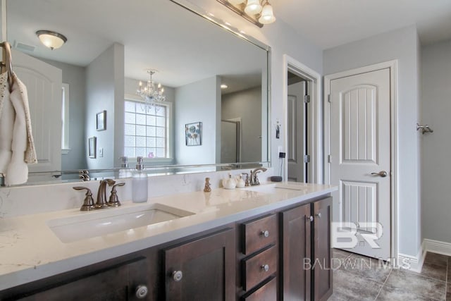 bathroom with tile patterned flooring, vanity, a shower with door, and a notable chandelier