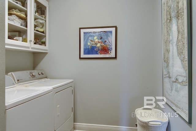 laundry room featuring cabinets and washer and clothes dryer