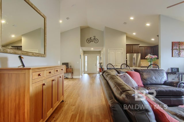 living room featuring high vaulted ceiling and light wood-type flooring