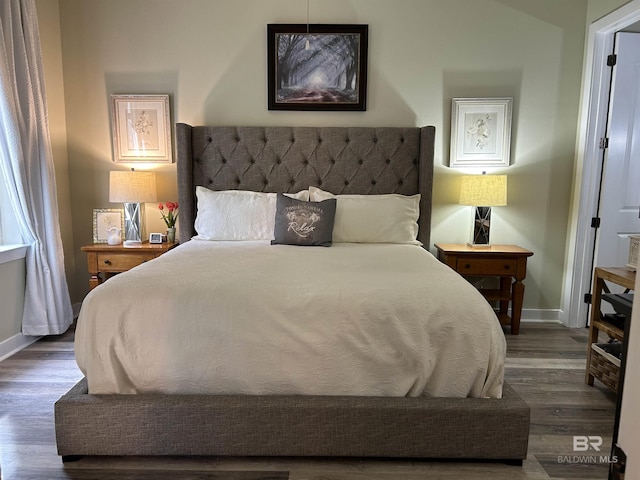 bedroom featuring baseboards and wood finished floors